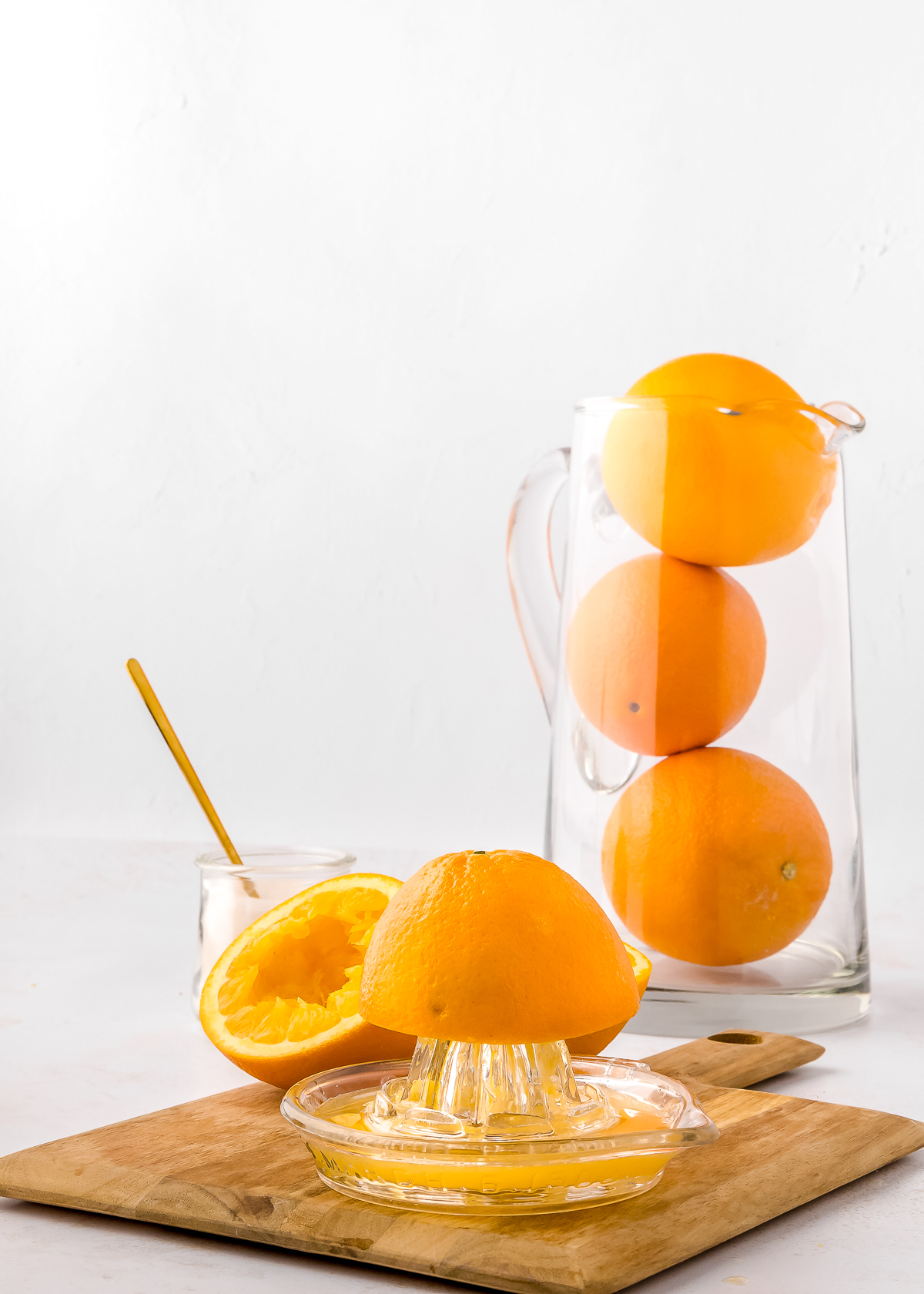 making orange juice on a glass citrus juicer with half an orange.