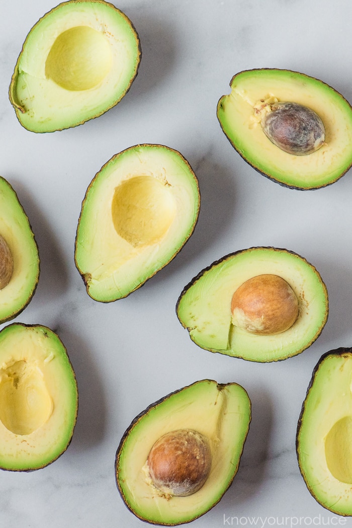 cut avocados on a marble slab for guacamole