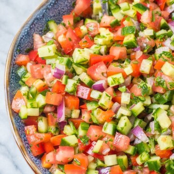 A colorful bowl of summer salads featuring summer pasta salad, summer fruit salad, and a summer strawberry salad with fresh ingredients.