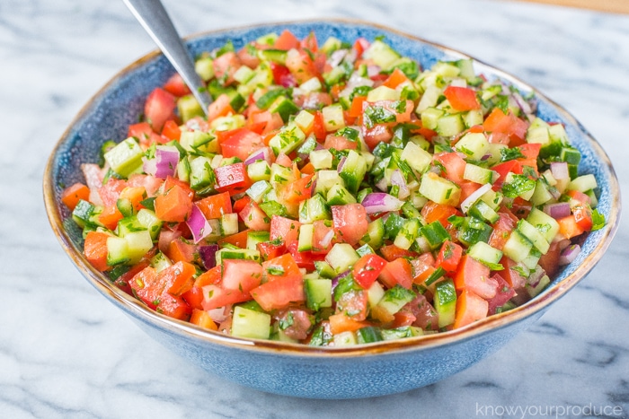 chopped israeli salad in a blue ceramic bowl