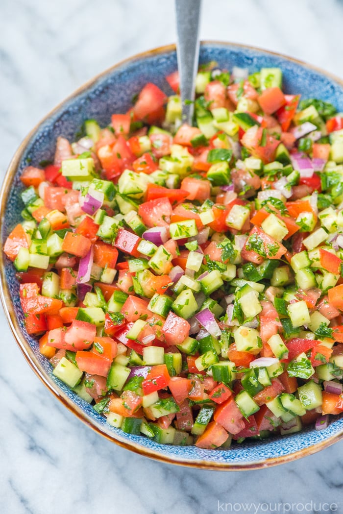 chopped middle eastern israeli salad in a blue bowl 