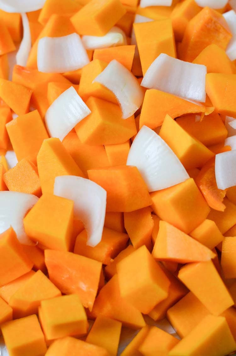 January Produce Guide - What's In Season chopped raw butternut squash and onions on a baking sheet ready to roast