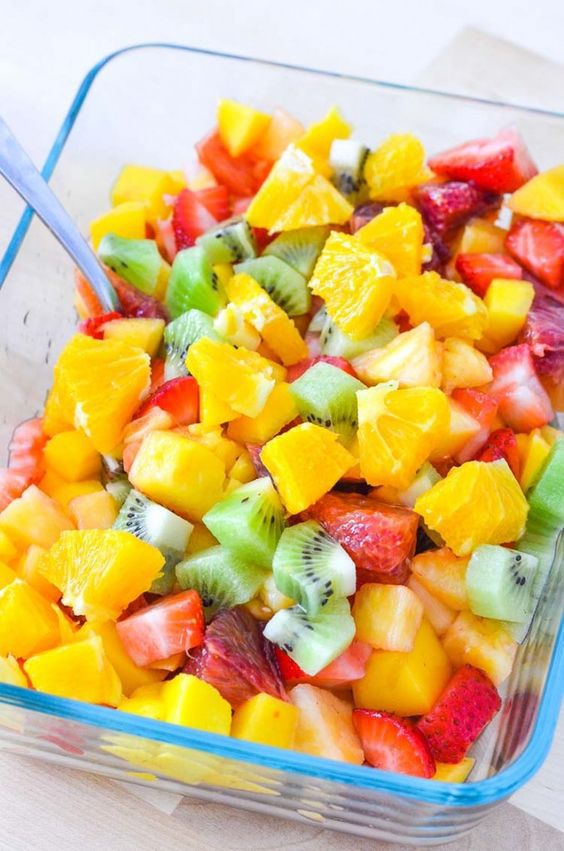 fruit salsa with citrus mango kiwi and strawberries in a glass pyrex dish with a serving spoon