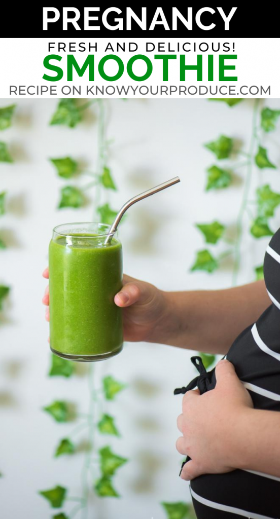 pregnancy smoothie in a glass with a stainless steel straw being held by a hand and hand holding a pregnant belly with greenery in the background pinterest image