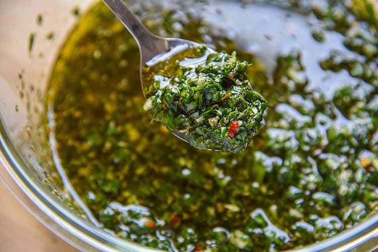 Try our homemade Argentinian Chimichurri Sauce and you'll be putting it on everything! Spoon closeup