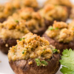 close up photo of a stuffed mushroom with more on a plate.