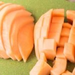 how to cut a cantaloupe cubes and wedges on a green cutting board