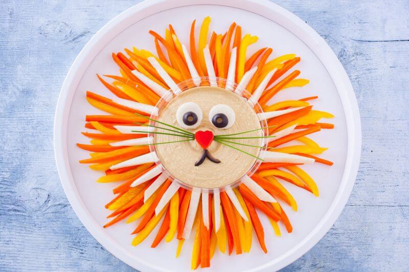 lion vegetable tray with hummus on a serving platter