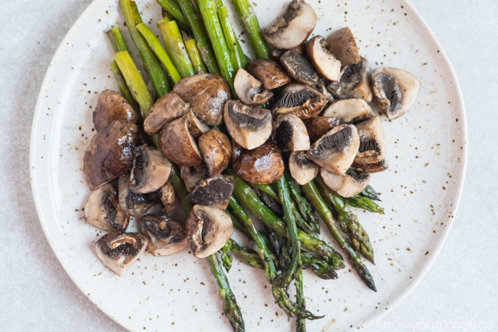 oven roasted asparagus and mushrooms on a speckled plate