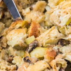 vegan stuffing with a serving spoon in a casserole dish