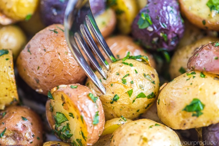 roasted baby potatoes with a fork on a sheet pan