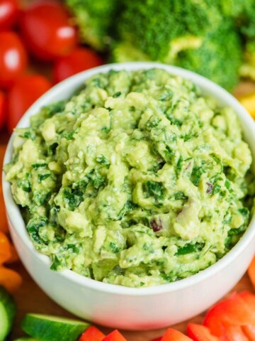 kale guacamole in a bowl with veggie platter