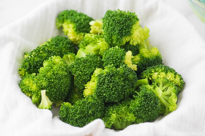 fresh steamed broccoli in a bowl with a white cloth