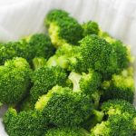 steamed broccoli in a bowl with a white cloth