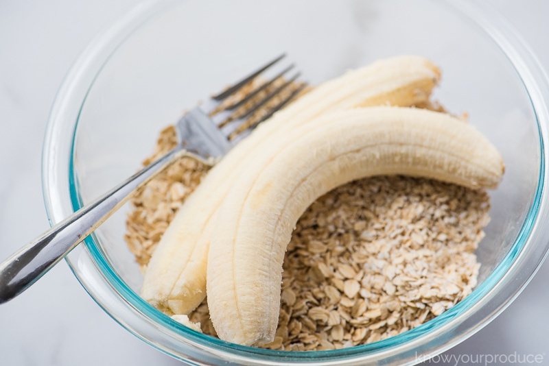 bananas and oatmeal in a glass bowl with fork 