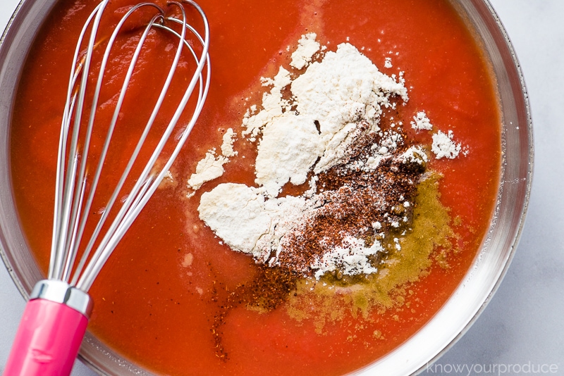 tomato sauce with seasonings in a skillet with whisk