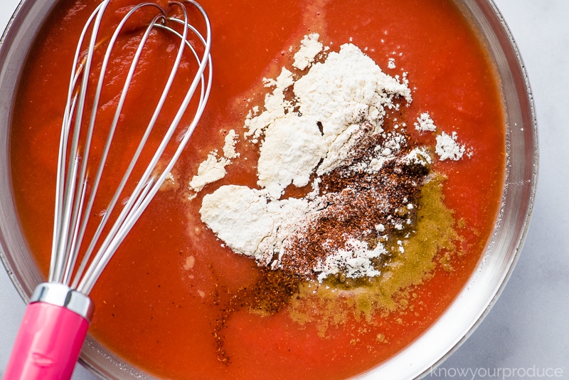 tomato sauce with seasonings in a skillet with whisk