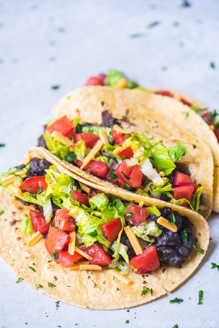 vegan tacos with black beans, lettuce, vegan cheese shreds, and fresh pico de gallo
