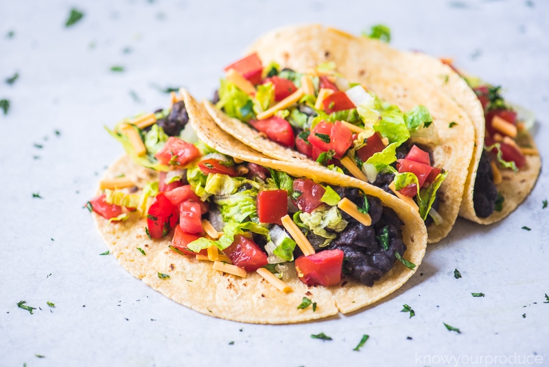soft vegan tacos with black beans, lettuce, vegan cheese shreds, and fresh pico de gallo