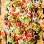 vegan nachos with black beans on a baking sheet