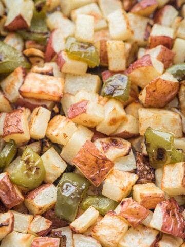 roasted potatoes peppers and onions on a sheet pan