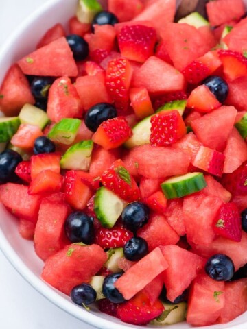 watermelon salad with blueberries cucumber and mint in a white low bowl