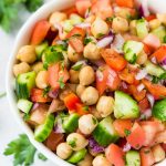 chickpea salad in a bowl with parsley on table