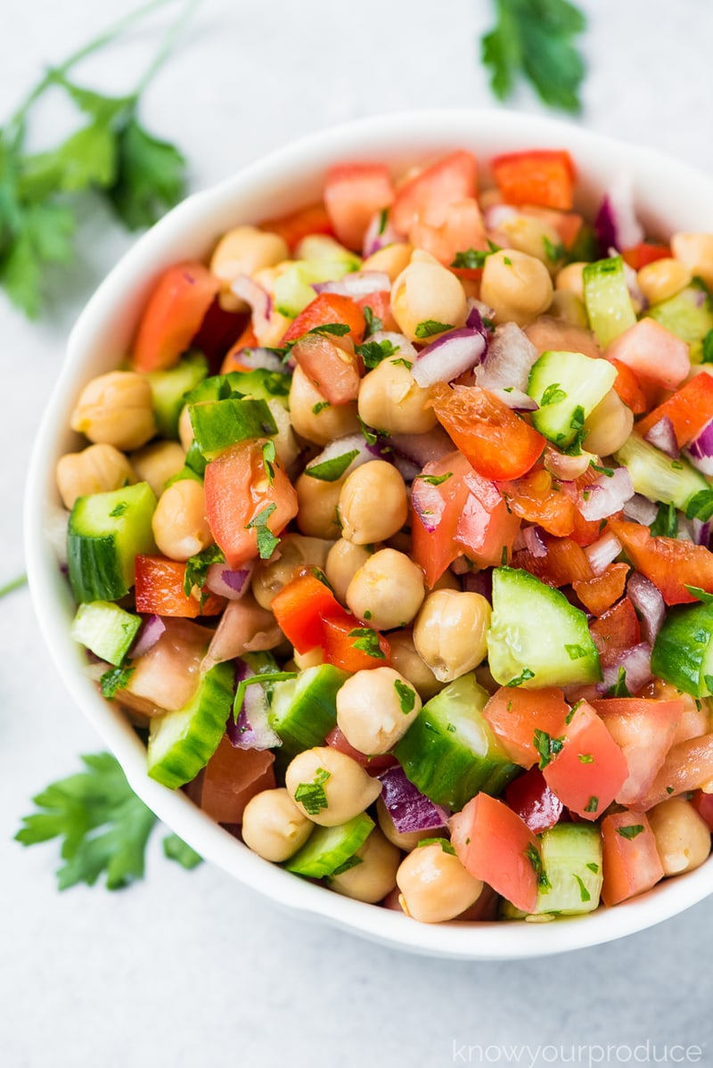 chickpea salad in a bowl with parsley on table