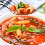 minestrone soup in a bowl and on a spoon