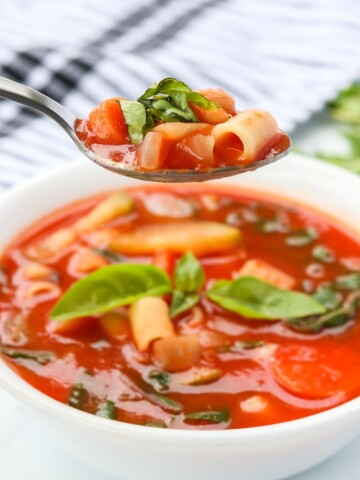 minestrone soup in a bowl and on a spoon