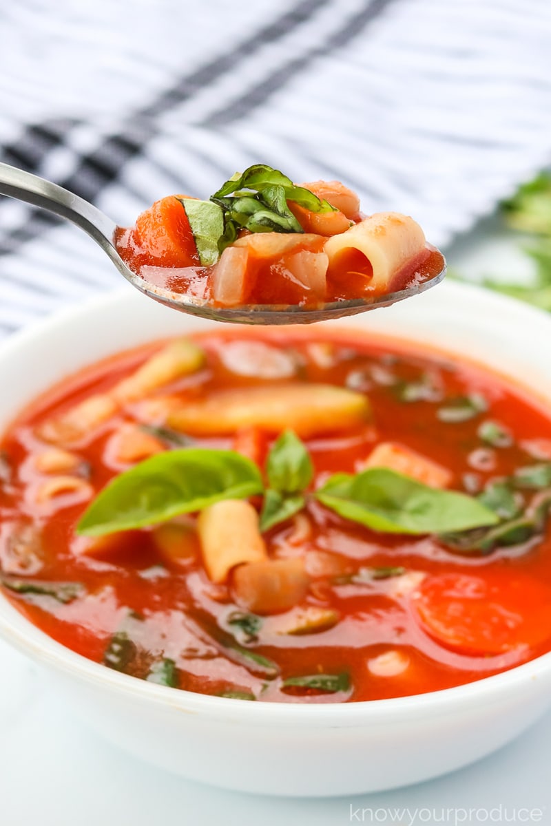 minestrone soup in a bowl and on a spoon