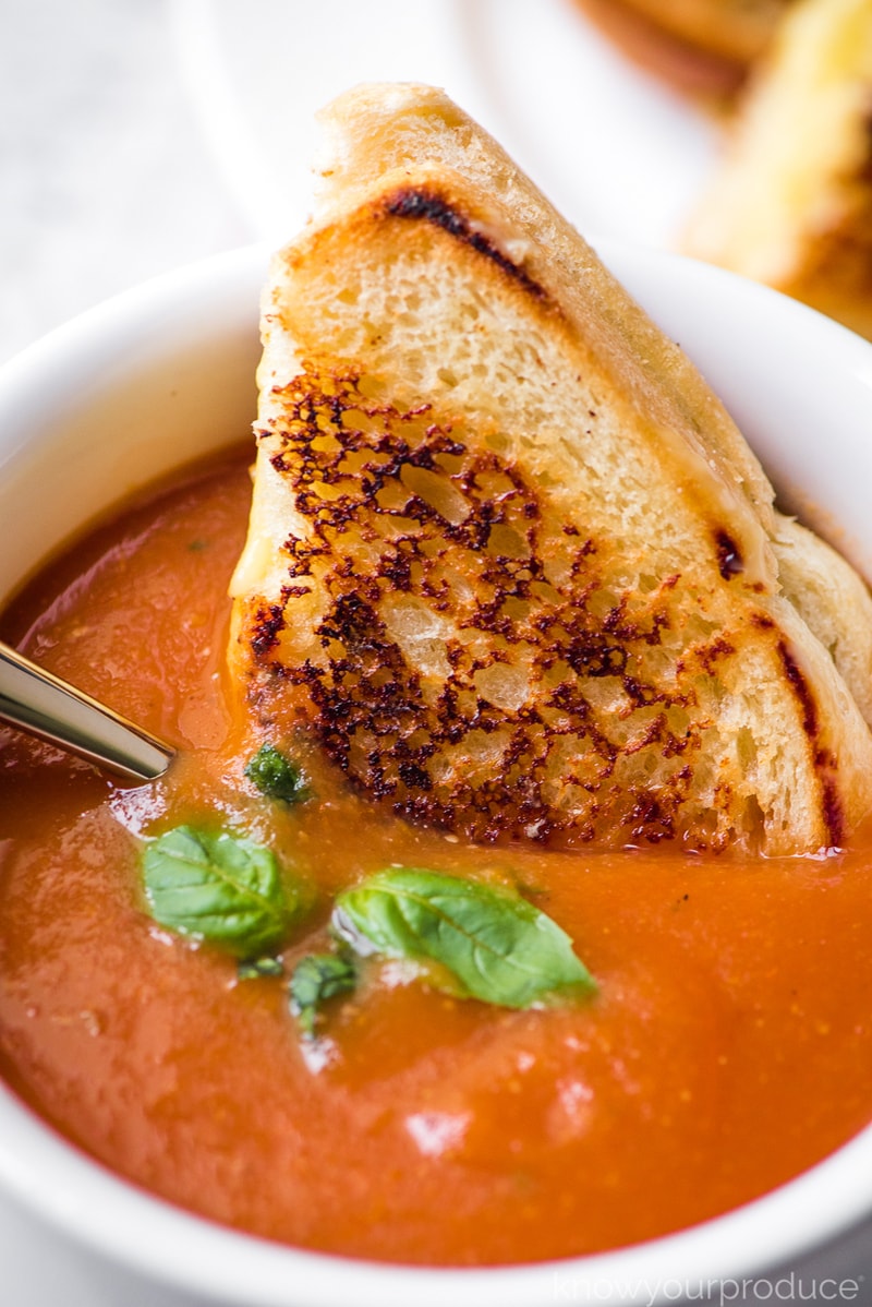 vegan grilled cheese in a bowl of tomato soup 