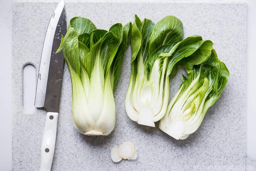 cut baby bok choy on a cutting board with cutco chef knife