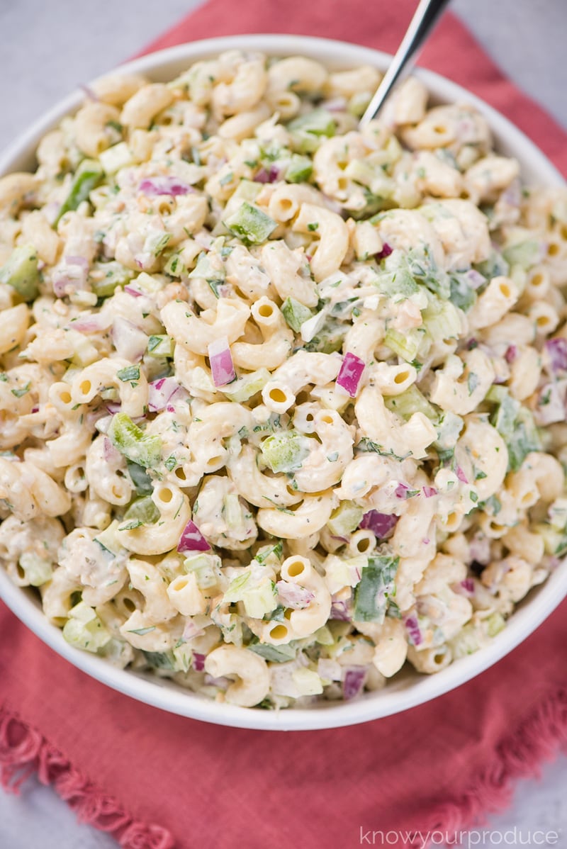 vegan tuna pasta salad in a white low bowl with spoon and pink cloth