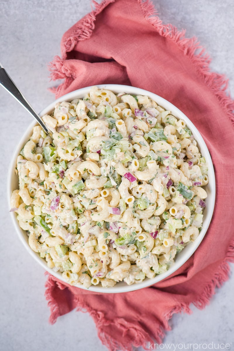 vegan tuna pasta salad in a bowl with a spoon and a pink hand towel