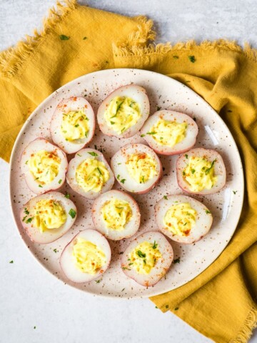 deviled potatoes on a speckled ceramic plate with mustard napkin