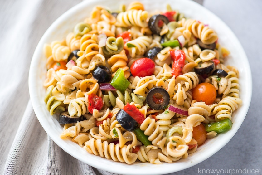 italian pasta salad in a white bowl with napkin to the left