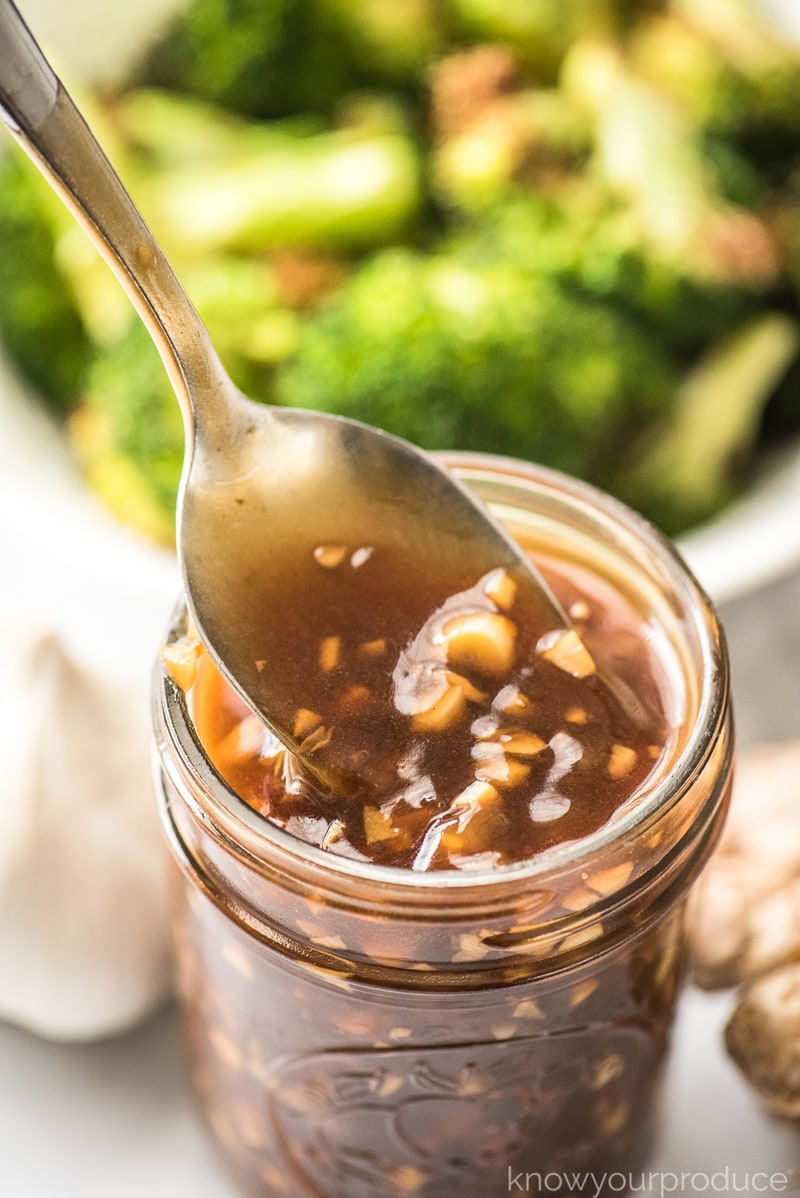 chinese garlic sauce in a mason jar with spoon and broccoli in bowl