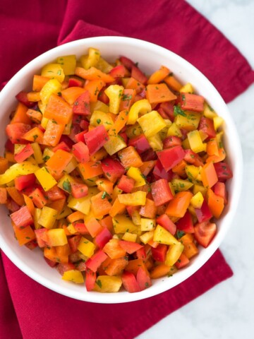 chopped bell pepper salad in a white bowl on a red napkin