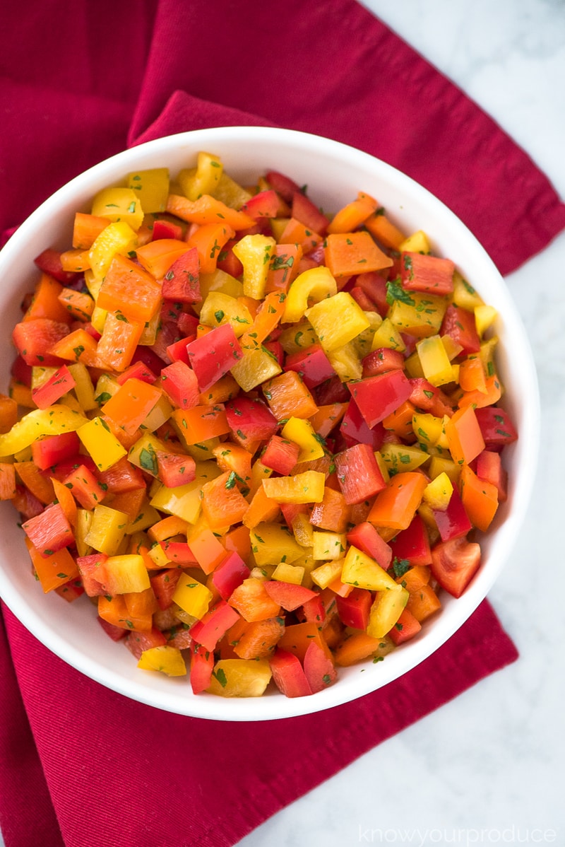 chopped bell pepper salad in a white bowl on a red napkin