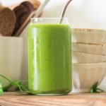 pregnancy smoothie on a wooden shelf with small bowls and cup with wooden spoons in background