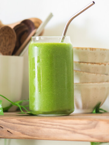 pregnancy smoothie on a wooden shelf with small bowls and cup with wooden spoons in background