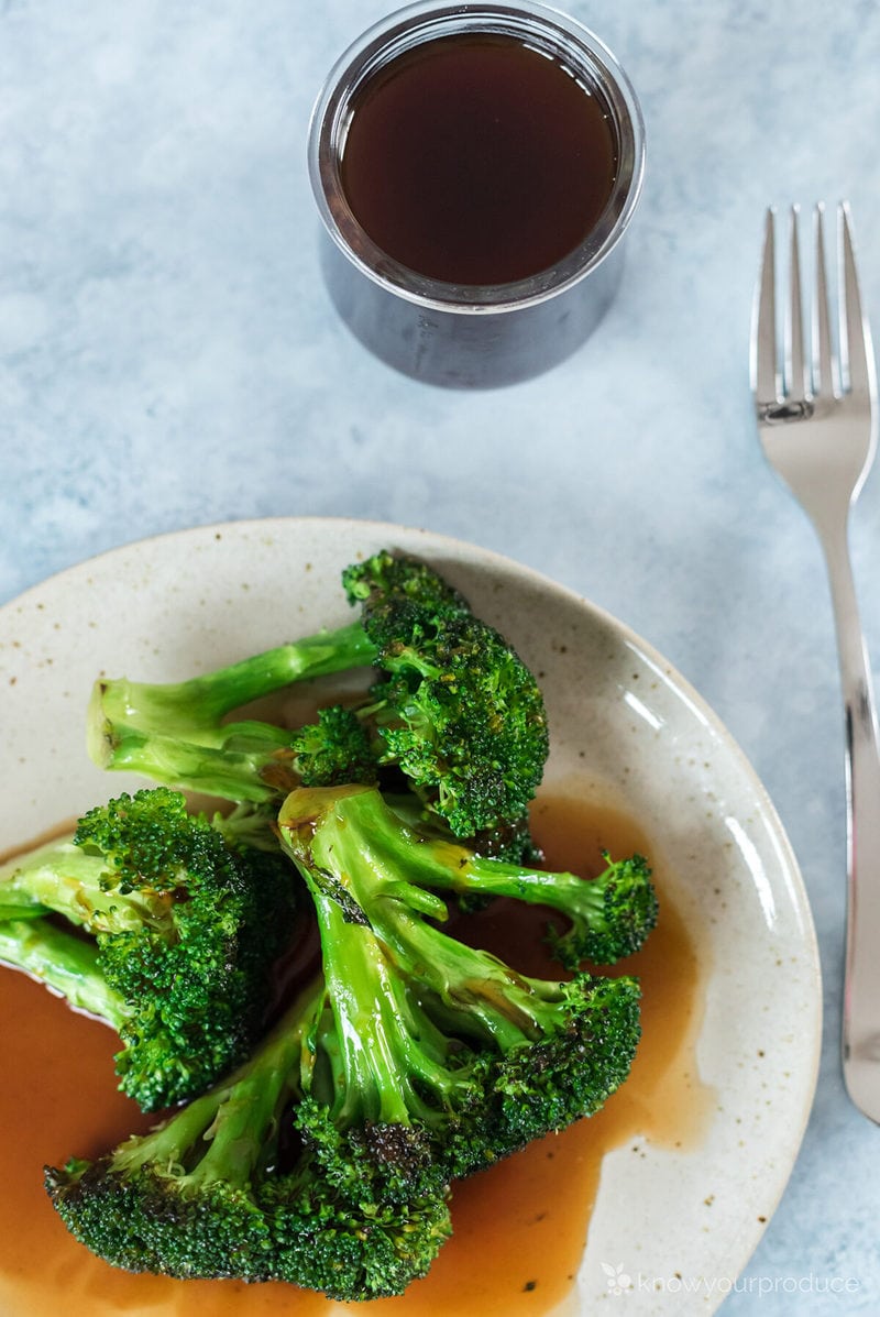 homemade teriyaki sauce in a small glass jar with teriyaki broccoli on a plate