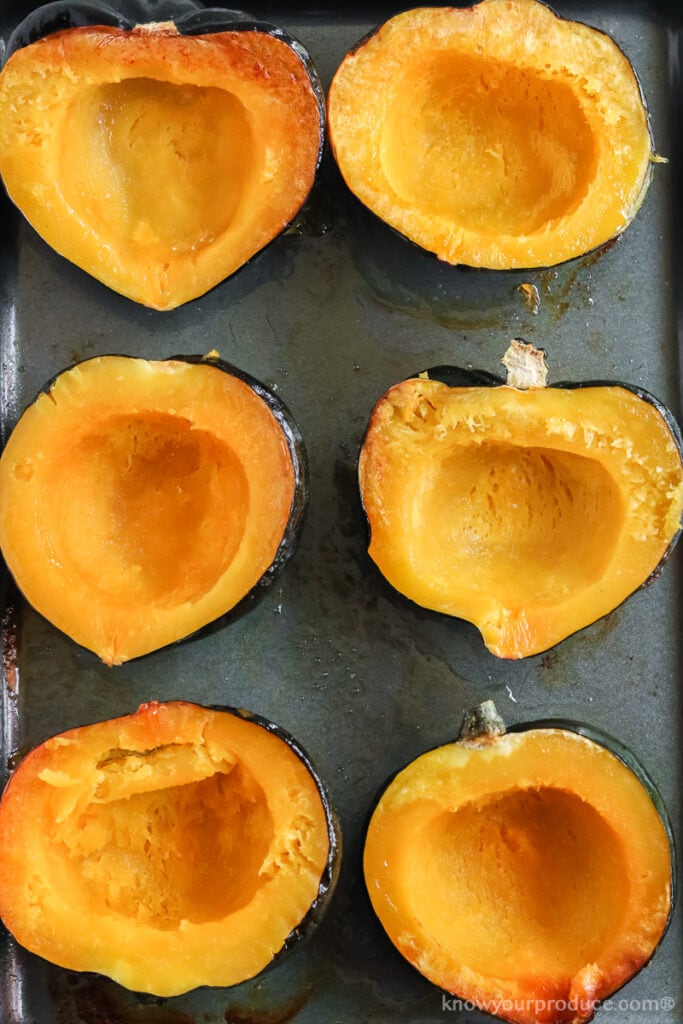 roasted acorn squash halves on a baking sheet pan