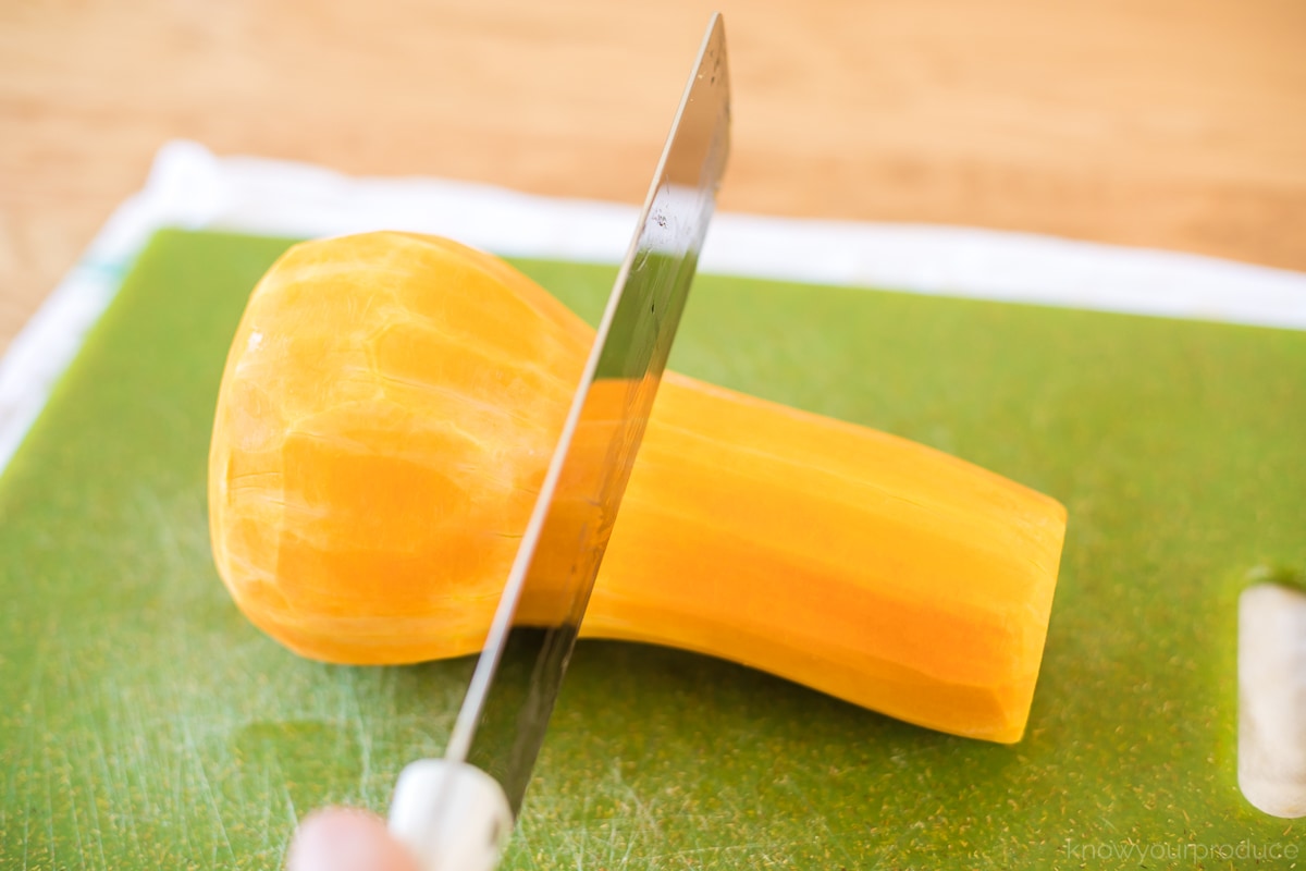 knife cutting butternut squash in half