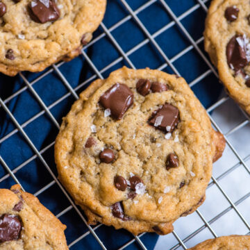 chocolate chip cookies on a cooling rack with blue napkin underneath