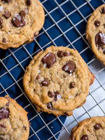 chocolate chip cookies on a cooling rack with blue napkin underneath