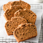 vegan gingerbread loaf cake on a cooling rack laid out on top of each other in a row