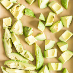 chunks of avocado on a baking sheet with parchment paper.