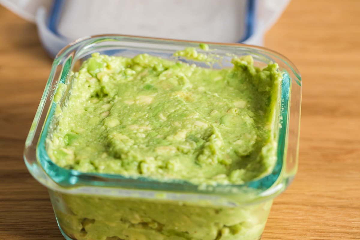 mashed avocado in a small pyrex container.